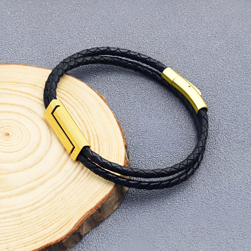 Bracelet cordon en cuir noir tressé avec fermoir séparé métallique doré élégant.