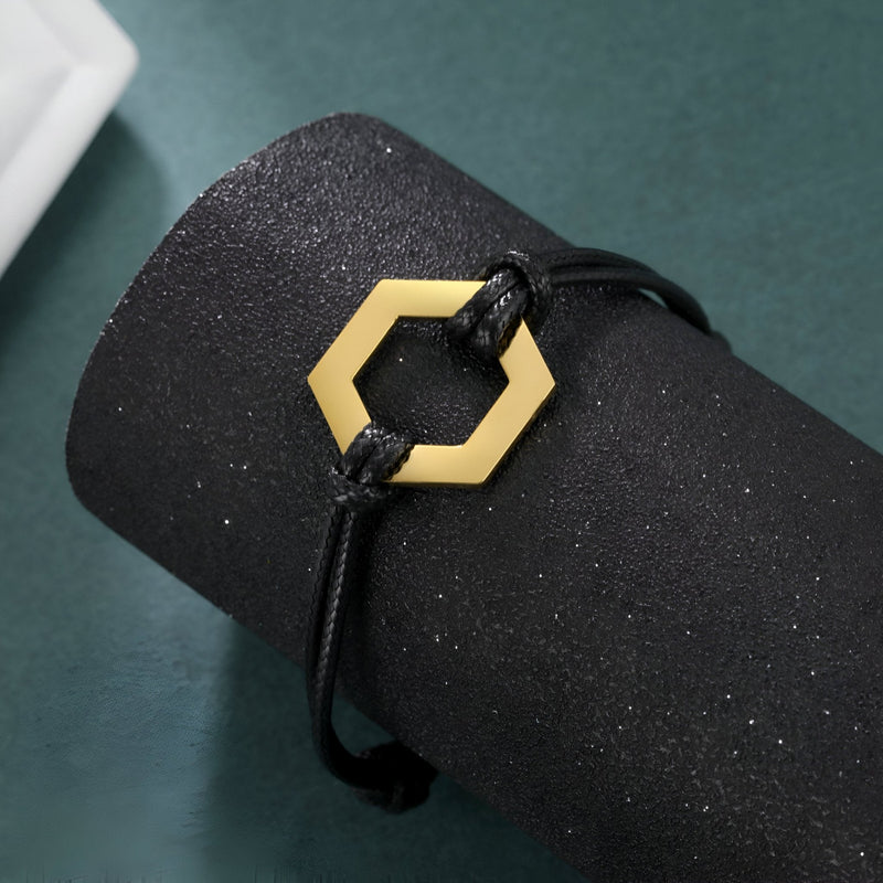 Bracelet cordon noir avec pendentif hexagone en acier inoxydable doré pour femme.