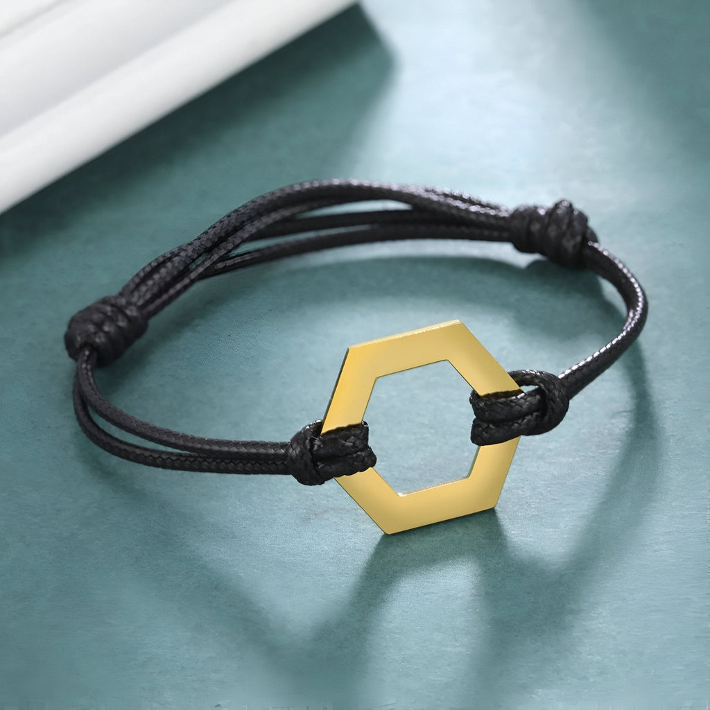 Bracelet cordon noir avec pendentif hexagone en acier inoxydable doré, modèle Mona pour femme.