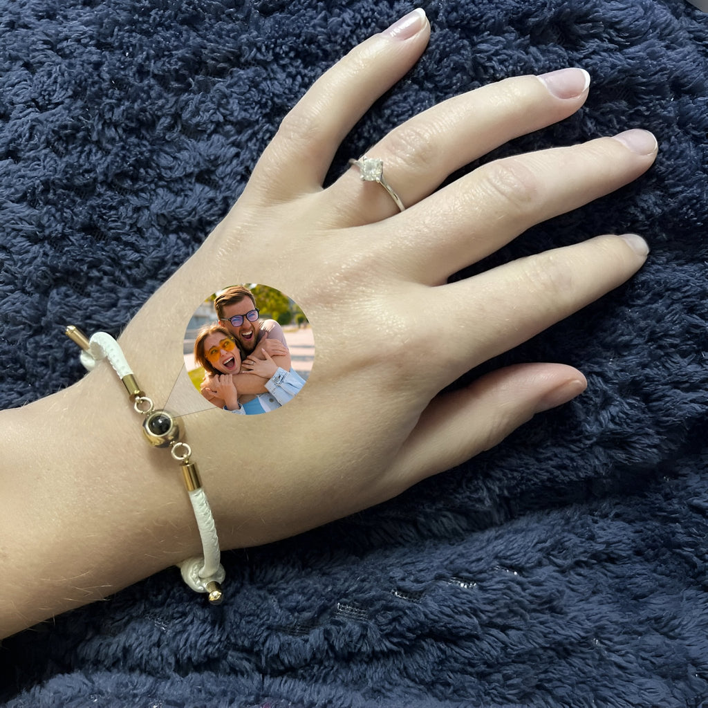 Bracelet photo personnalisé en cuir blanc avec détail en acier inoxydable or et orné de perles rondes noires.