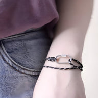 Bracelet cordon noir à double tour avec mousqueton argenté, style moderne et épuré.