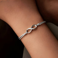 Bracelet cordon gris avec charm infini en argent sterling style minimaliste pour femme.