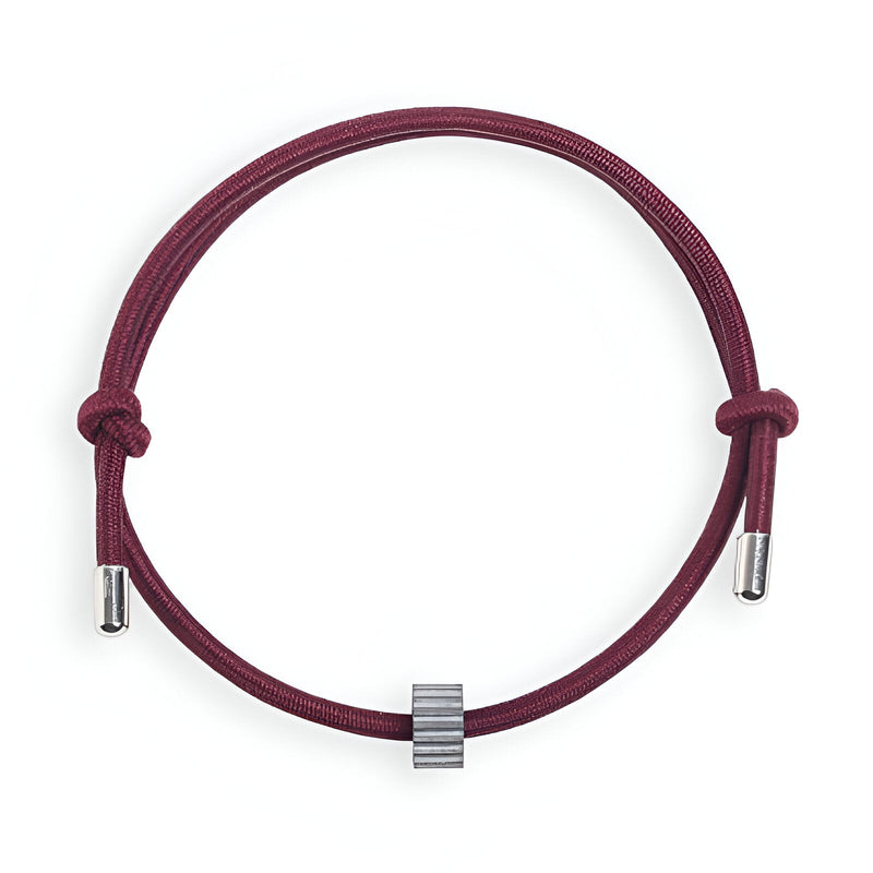 Bracelet cordon bordeaux avec ornement central en carbure de tungstène gris côtelé.