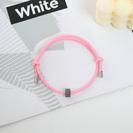 Bracelet cordon rose avec ornement en carbure de tungstène gris aux extrémités métalliques.