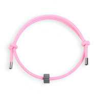 Bracelet cordon rose avec ornement cylindrique en carbure de tungstène gris anthracite.