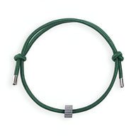 Bracelet cordon vert avec ornement cylindrique en carbure de tungstène gris.