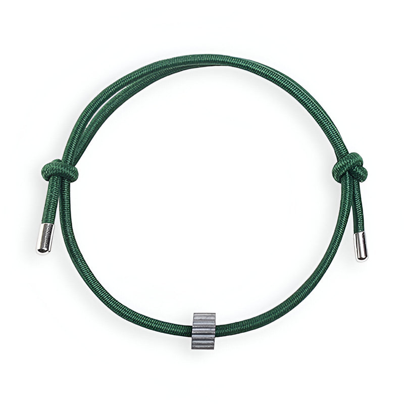 Bracelet cordon vert avec ornement cylindrique en carbure de tungstène gris.
