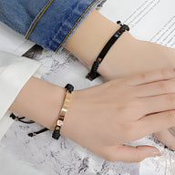 Bracelet cordon noir avec chaîne gourmette or rosé et cube zirconium en acier inoxydable.