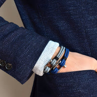 Bracelet cordon bleu homme avec mousqueton argenté et détails en cuir noir et marron.