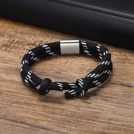 Bracelet cordon noir à rayures blanches avec fermoir métallique argenté pour homme.