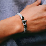 Bracelet cordon gris pour homme en coton avec fermoir métallique noir mat, design épuré.