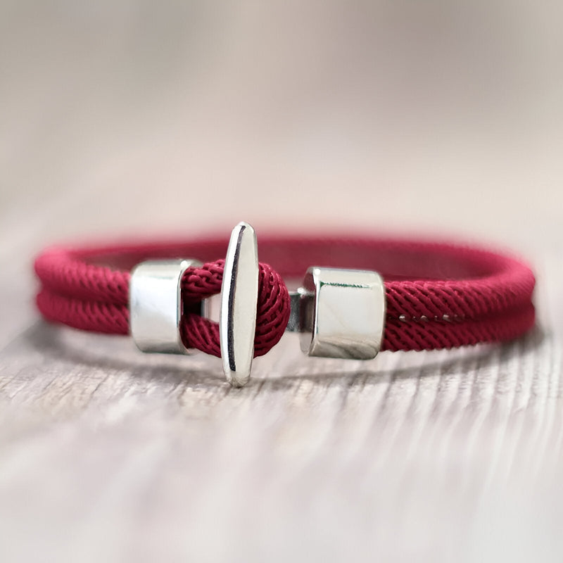 Bracelet cordon rouge en coton avec fermoir argenté en forme de barre, style masculin élégant.