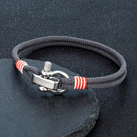 Bracelet cordon gris avec manille en acier inoxydable et détails rouges blancs.
