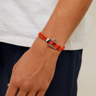 Bracelet cordon orange pour homme avec manille en acier inoxydable et détail bleu et blanc.