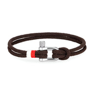 Bracelet cordon marron avec manille en acier inoxydable et détail rouge sur la fermeture.