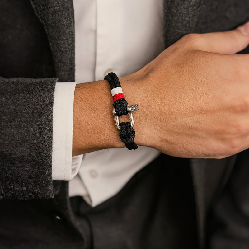 Bracelet cordon noir avec manille en acier inoxydable et détail tricolore rouge blanc bleu.