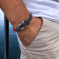Bracelet cordon gris avec mousqueton argenté et détail rouge, style décontracté pour homme.