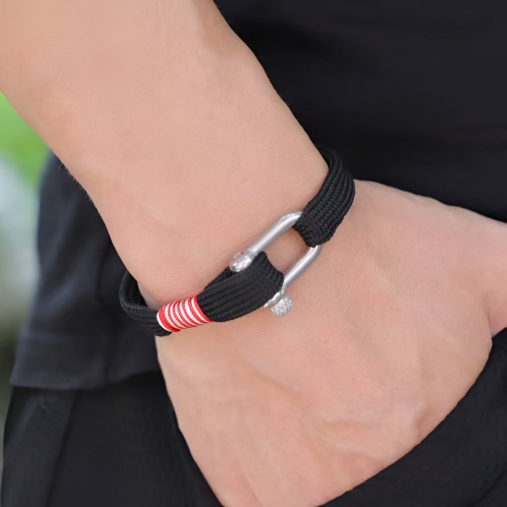 Bracelet cordon noir pour homme avec mousqueton argenté et détail rouge rayé.