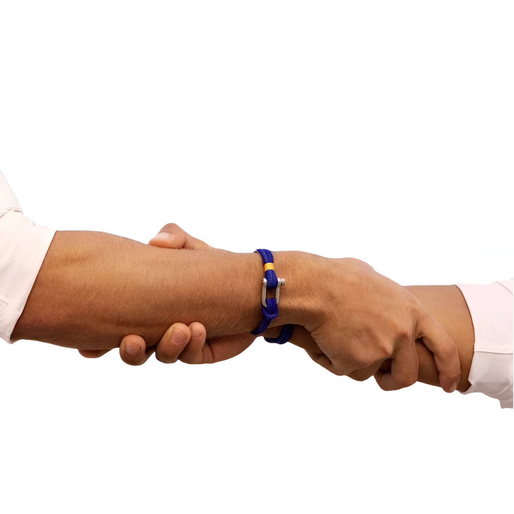 Bracelet cordon bleu avec mousqueton argenté porté sur poignet masculin en prise de main.