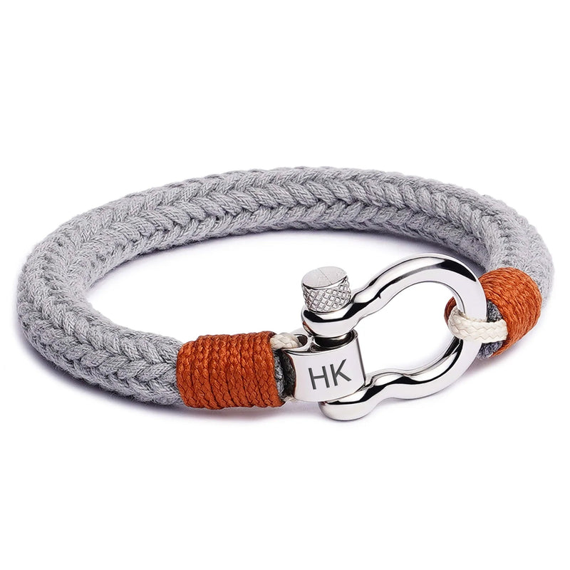 Bracelet cordon gris avec mousqueton arrondi en métal argenté et détails orange tissés.