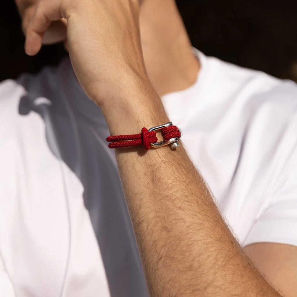 Bracelet cordon rouge pour homme avec mousqueton argenté moderne sur poignet.