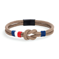 Bracelet cordon beige avec noeud et détail tricolore bleu blanc rouge, fermoir noir mat.