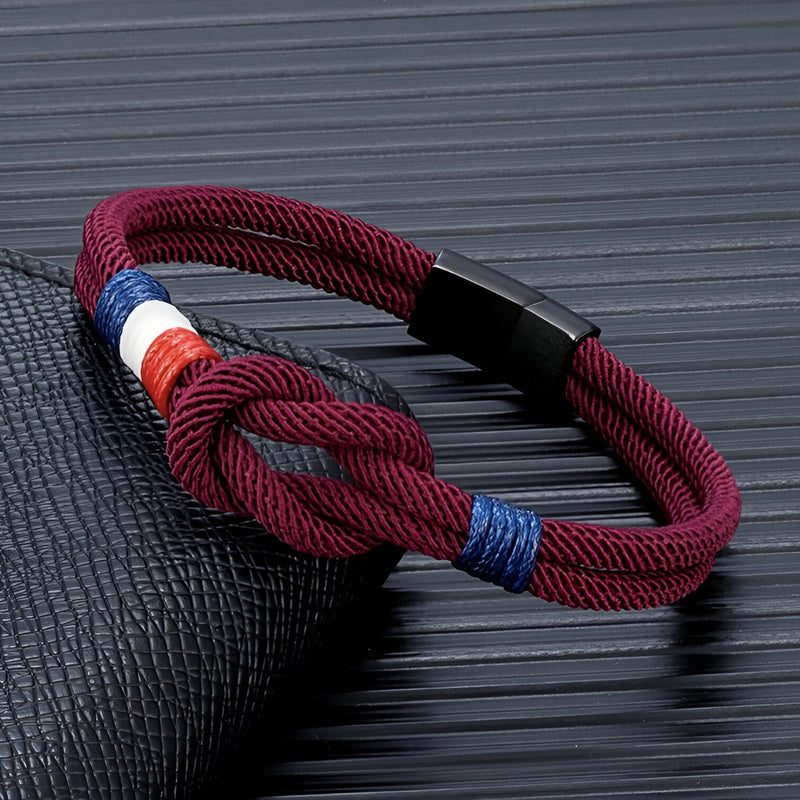Bracelet cordon bordeaux avec nœud et drapeau français tricolore, fermoir noir mat.