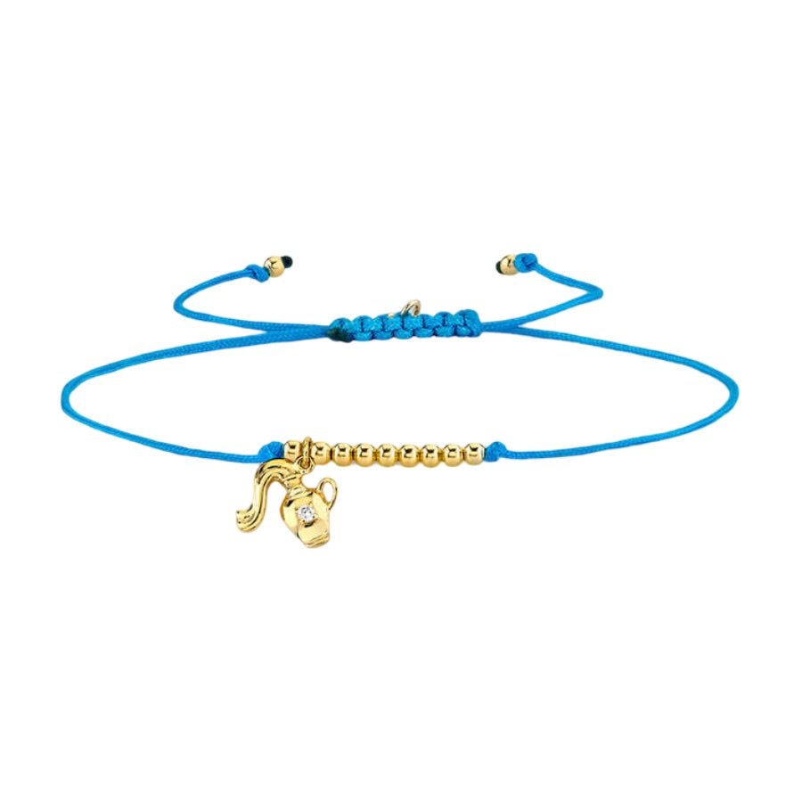 Bracelet cordon bleu avec breloques signe astrologique Bélier en métal doré et perles dorées ajustable.