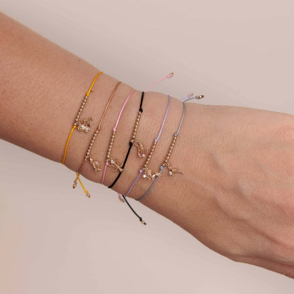 Bracelets cordon multicolores avec signes du zodiaque en perles dorées, style fin et ajustable.