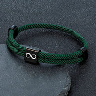 Bracelet cordon vert foncé avec plaque acier inoxydable noire gravée d’un signe infini, ajustable.