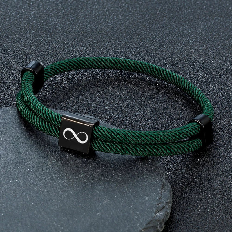 Bracelet cordon vert foncé avec plaque acier inoxydable noire gravée d’un signe infini, ajustable.
