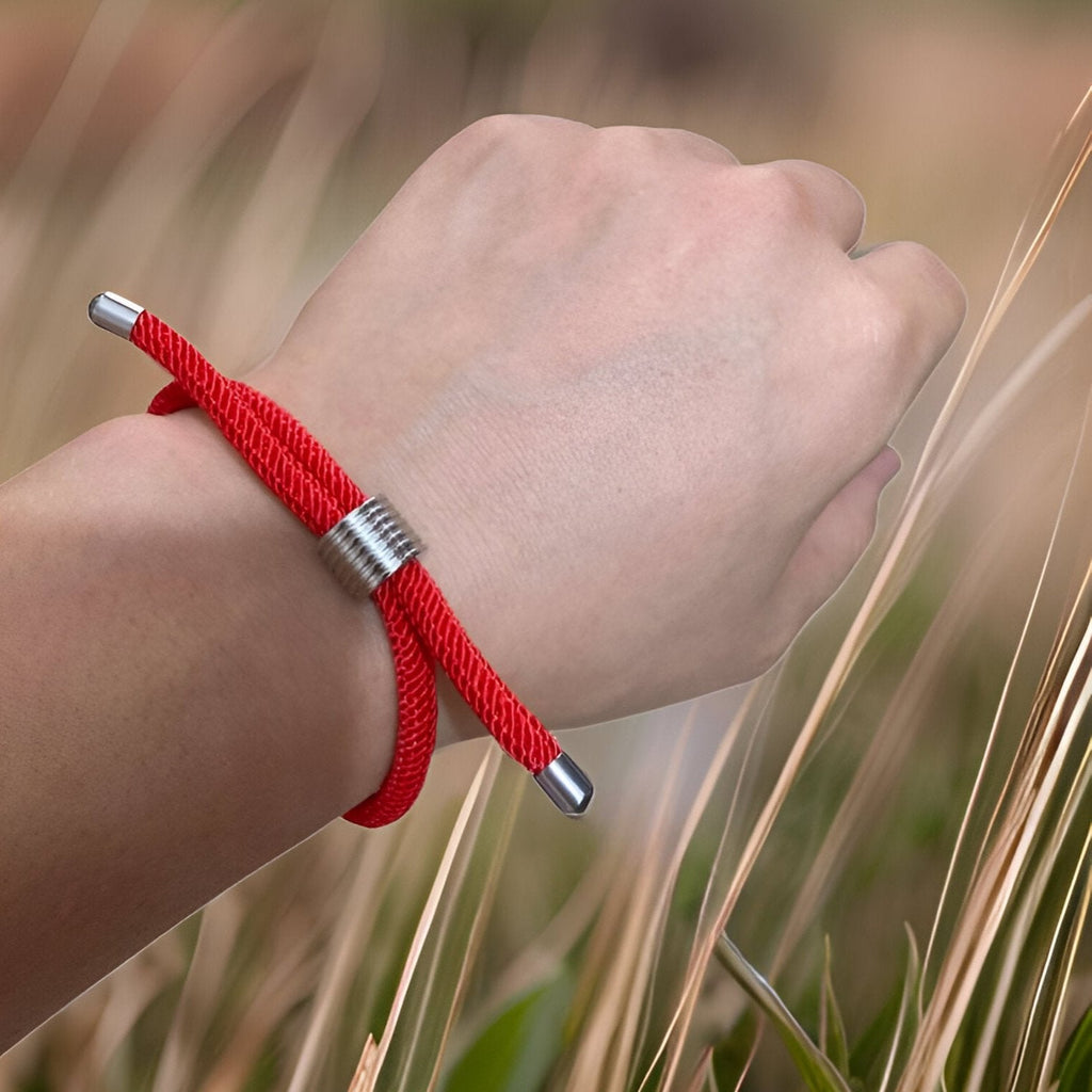 Bracelet cordon rouge simple avec embouts et perle métallique, style discret pour homme.