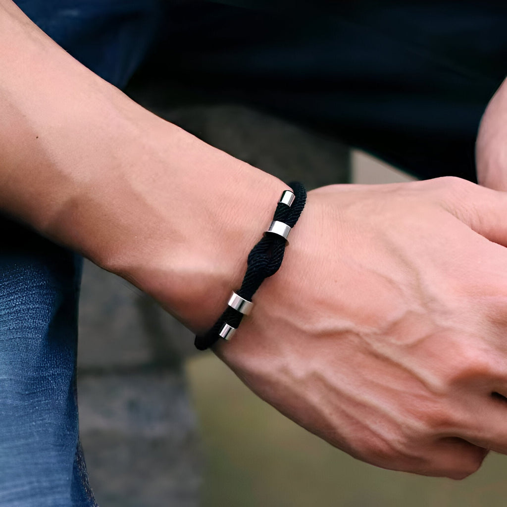 Bracelet cordon noir pour homme avec nœud plat et perles métalliques argentées.
