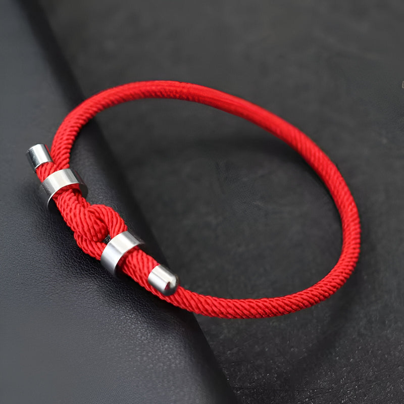 Bracelet cordon rouge simple avec ajusteur et embouts en métal argenté élégant.