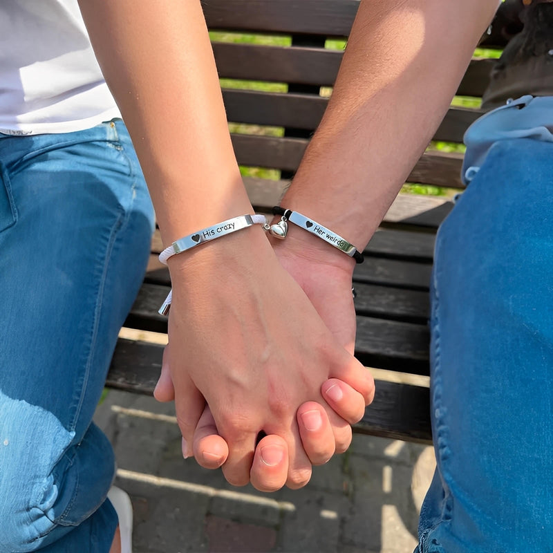Bracelets couple en corde noire avec plaques en acier inoxydable gravées et fermoirs cœurs aimantés élégants.