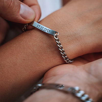 Bracelet couple gourmette en acier inoxydable argenté avec gravure date et cœur, design élégant et chaîne épaisse.