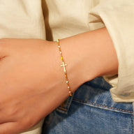 Bracelet fin en argent sterling avec petite croix chrétienne, style délicat pour femme.