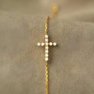 Bracelet fin en argent sterling avec croix scintillante ornée de petites pierres brillantes.