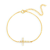 Bracelet fin en or avec croix chrétienne scintillante ornée de petits strass.