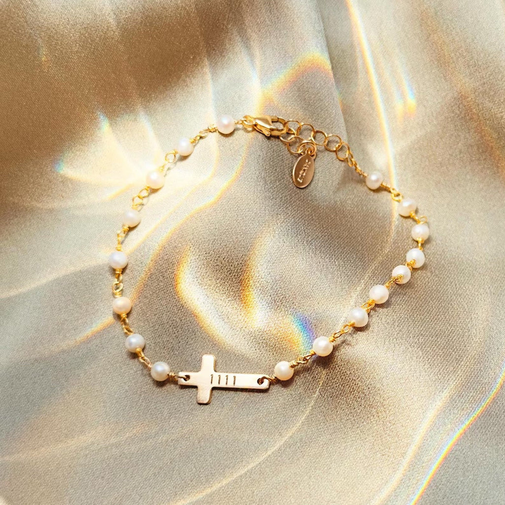 Bracelet délicat perles d’eau douce blanches et croix dorée en acier inoxydable style Dalila.