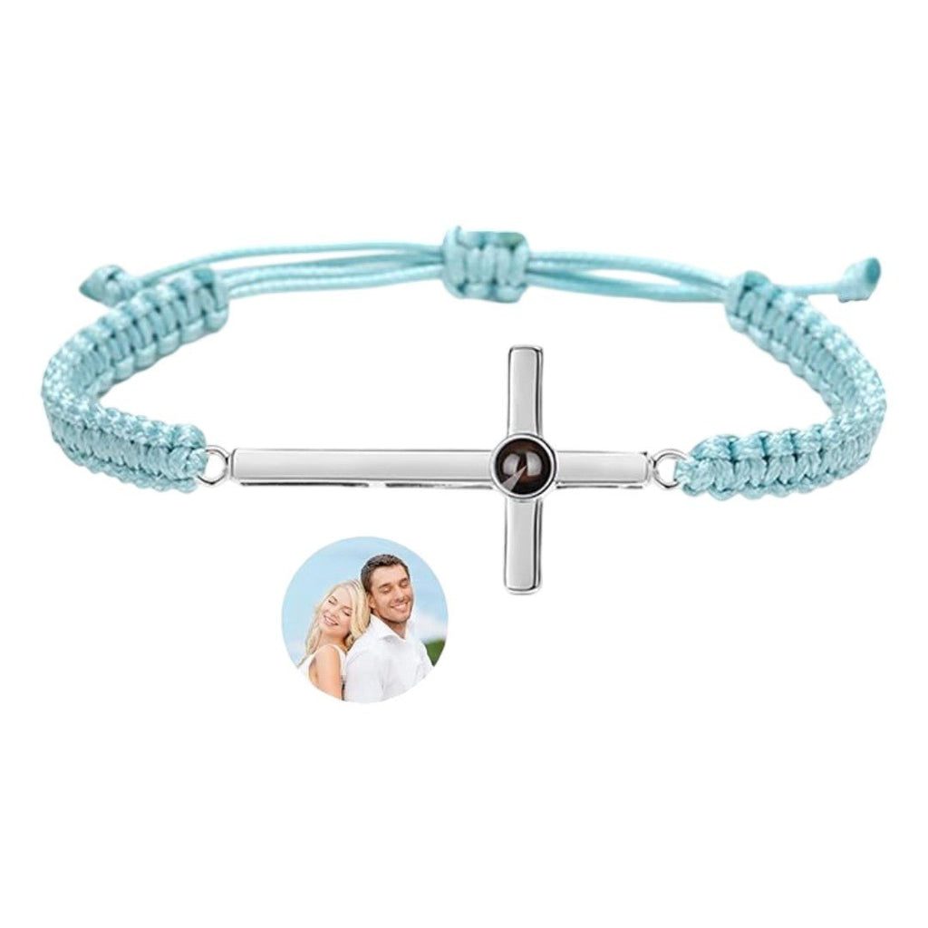 Bracelet corde bleu clair avec pendentif croix argent gravé d'une photo ronde au centre.