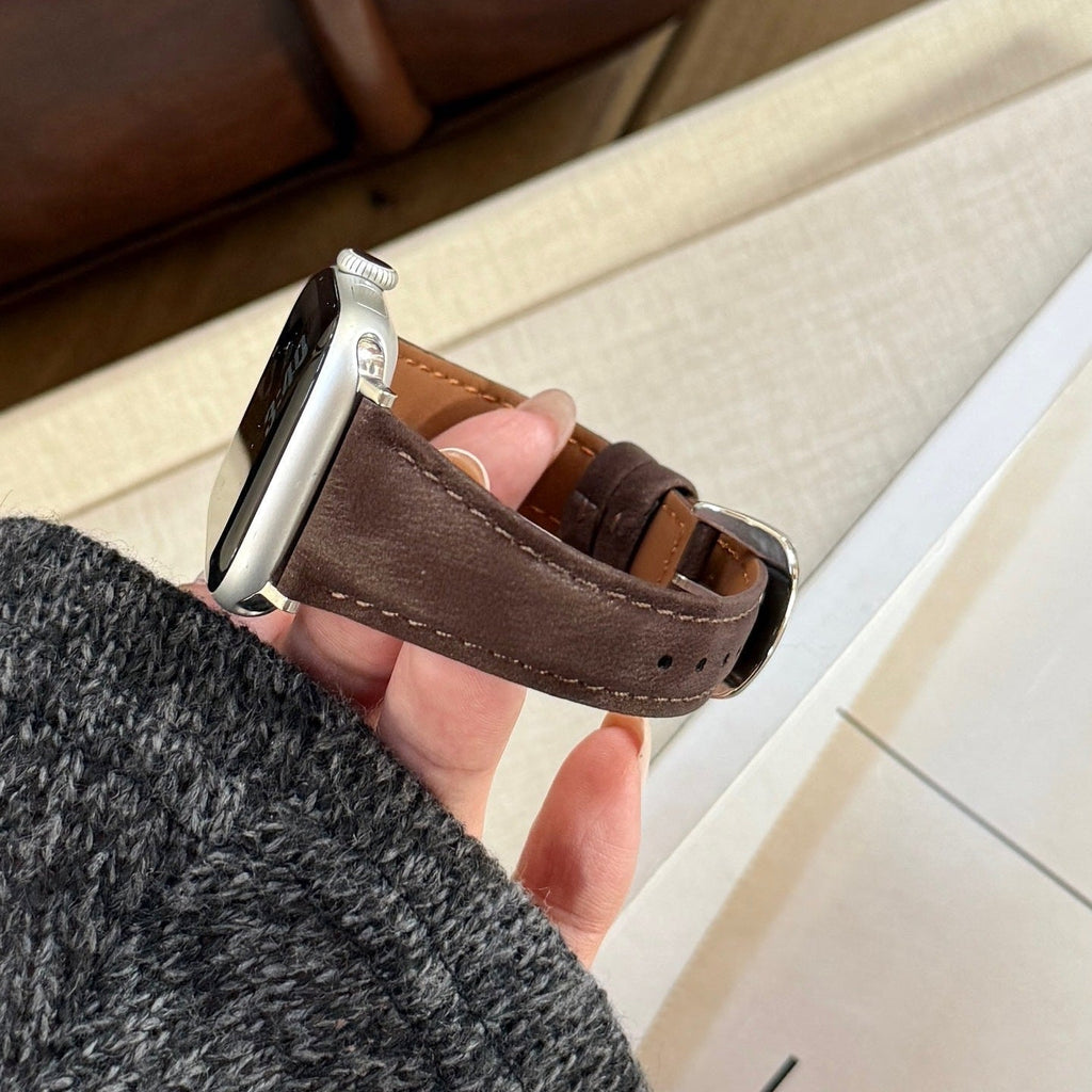 Bracelet en cuir marron foncé pour Apple Watch avec boucle argentée élégante et coutures apparentes.