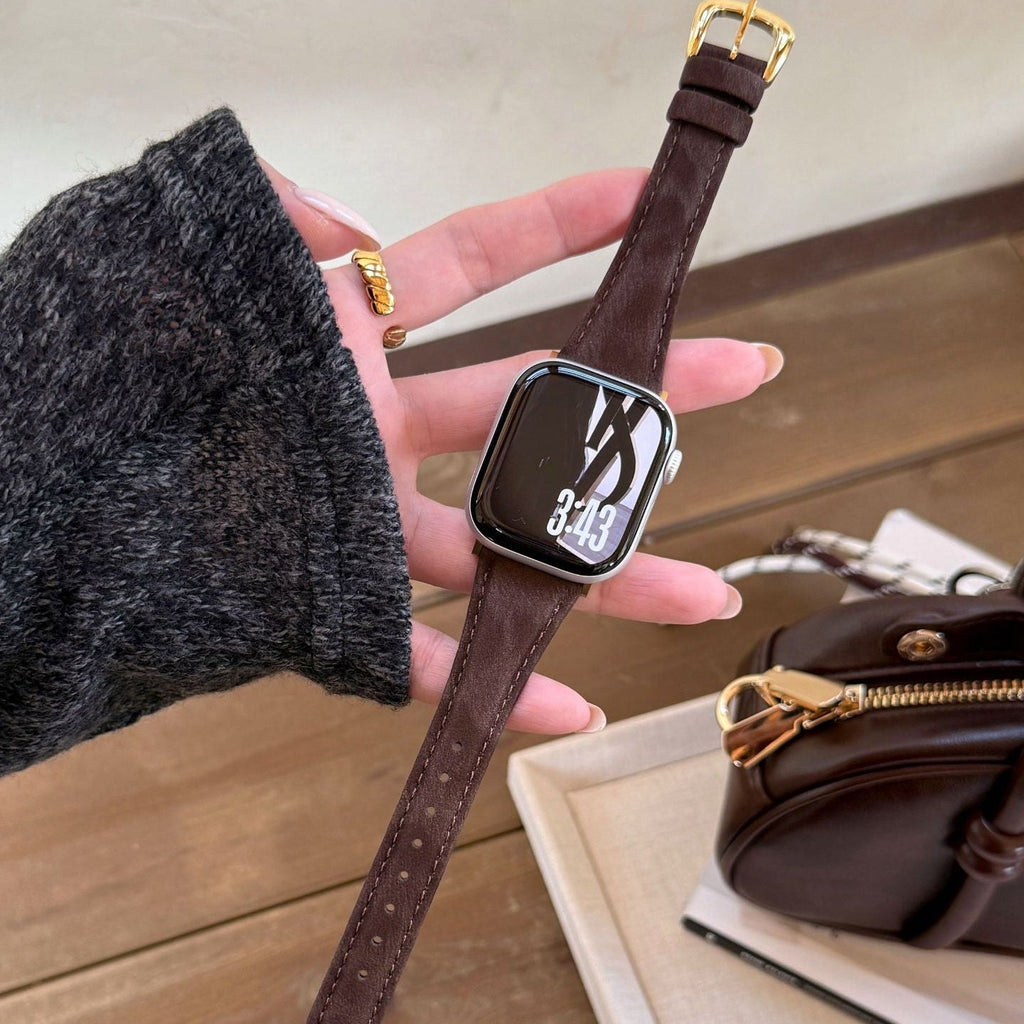 Bracelet en cuir marron foncé pour Apple Watch avec boucle dorée, style élégant et finitions soignées.