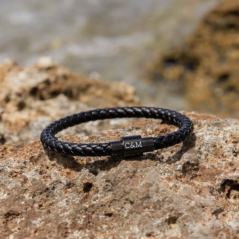 Bracelet en cuir noir tressé avec fermoir magnétique en métal gravé des initiales C&M.