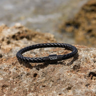 Bracelet en cuir noir tressé avec fermoir magnétique en métal gravé des initiales C&M.