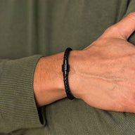 Bracelet homme en cuir noir tressé avec fermoir magnétique en acier gravé d'initiales.