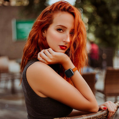 Bracelet en cuir pleine fleur marron avec boucle ovale élégante pour Apple Watch, porté au poignet féminin.