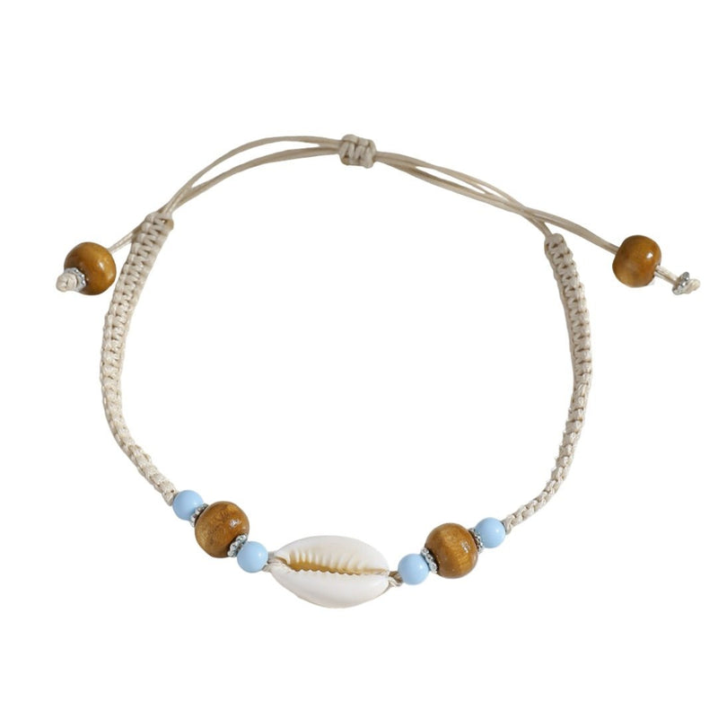Bracelet de cheville beige en corde tressée avec coquillage central et perles marron et bleues.