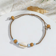 Bracelet de cheville marron en corde avec coquillage blanc et perles bleues et en bois naturel.