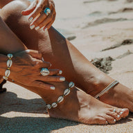 Bracelet de cheville en corde marron avec coquillages blancs, style bohème estival.